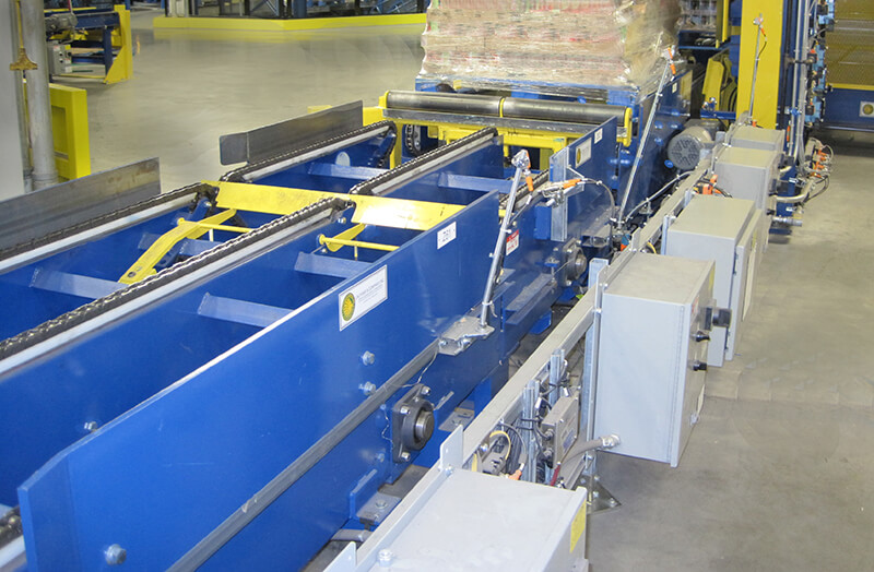 Three-Strand chain conveyors transferring 3,000 pound pallet loads in dry goods distribution warehouse.