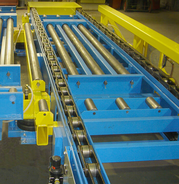 Heavy duty Two-Strand chain conveyor with roller transfer to convey 14,000 pound pallet loads.